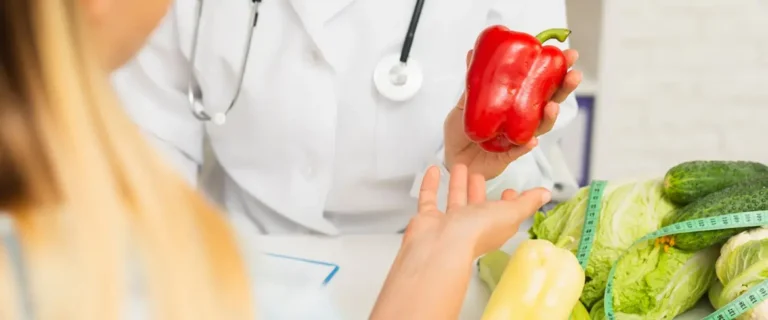 dietetyk podający kobiecie czerwoną&nbsp;paprykę