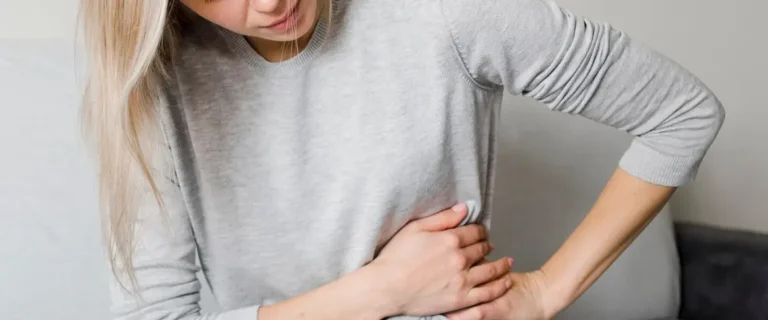 kobieta chwyta się swojej&nbsp;talii z powodu bólu